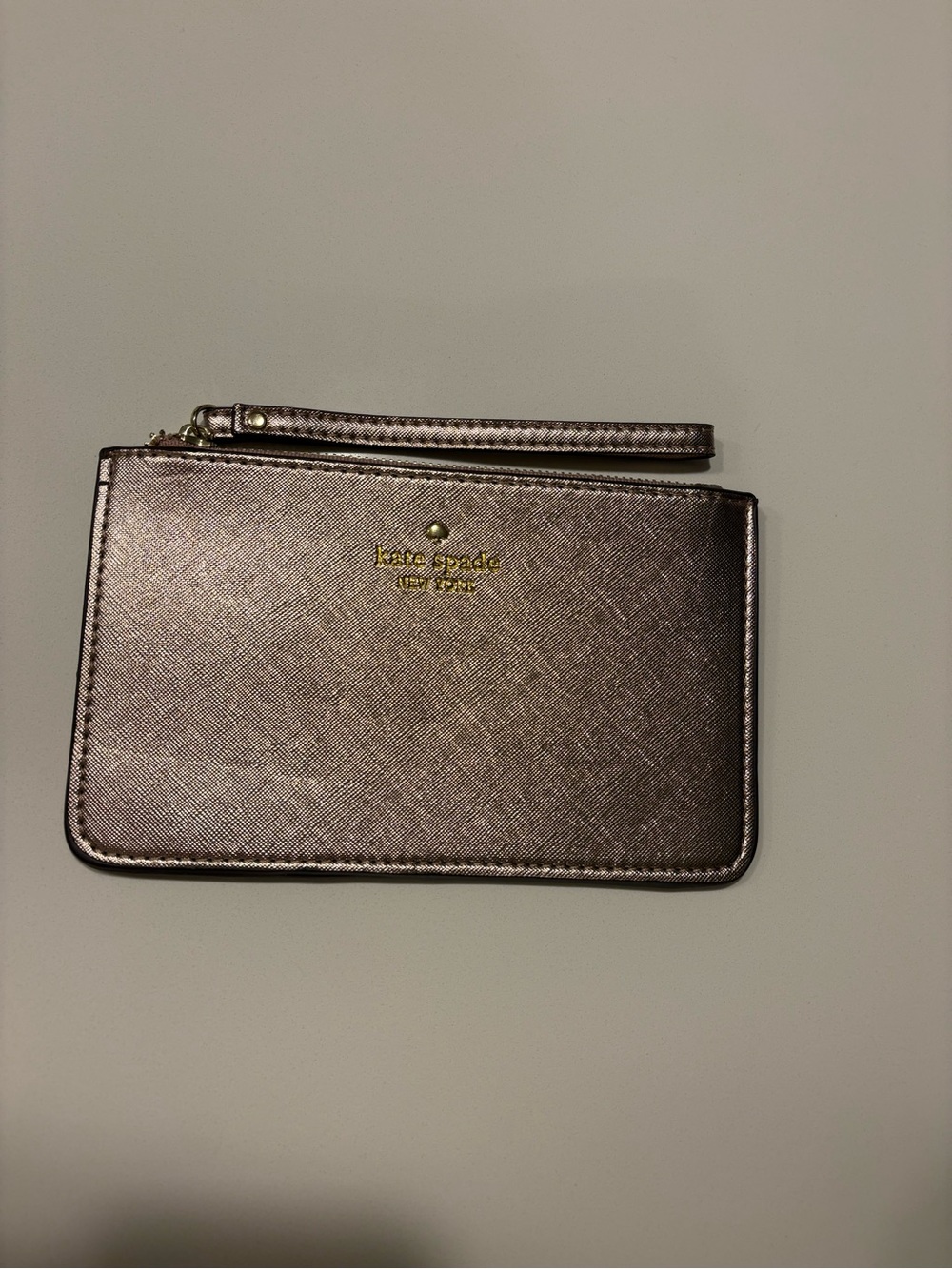 kate spade metallic rose gold wristlet with gold logo
